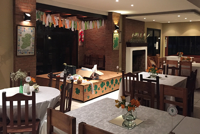 El salón comedor del club, con mesas puestas y detalles irlandeses en la vidriera.
